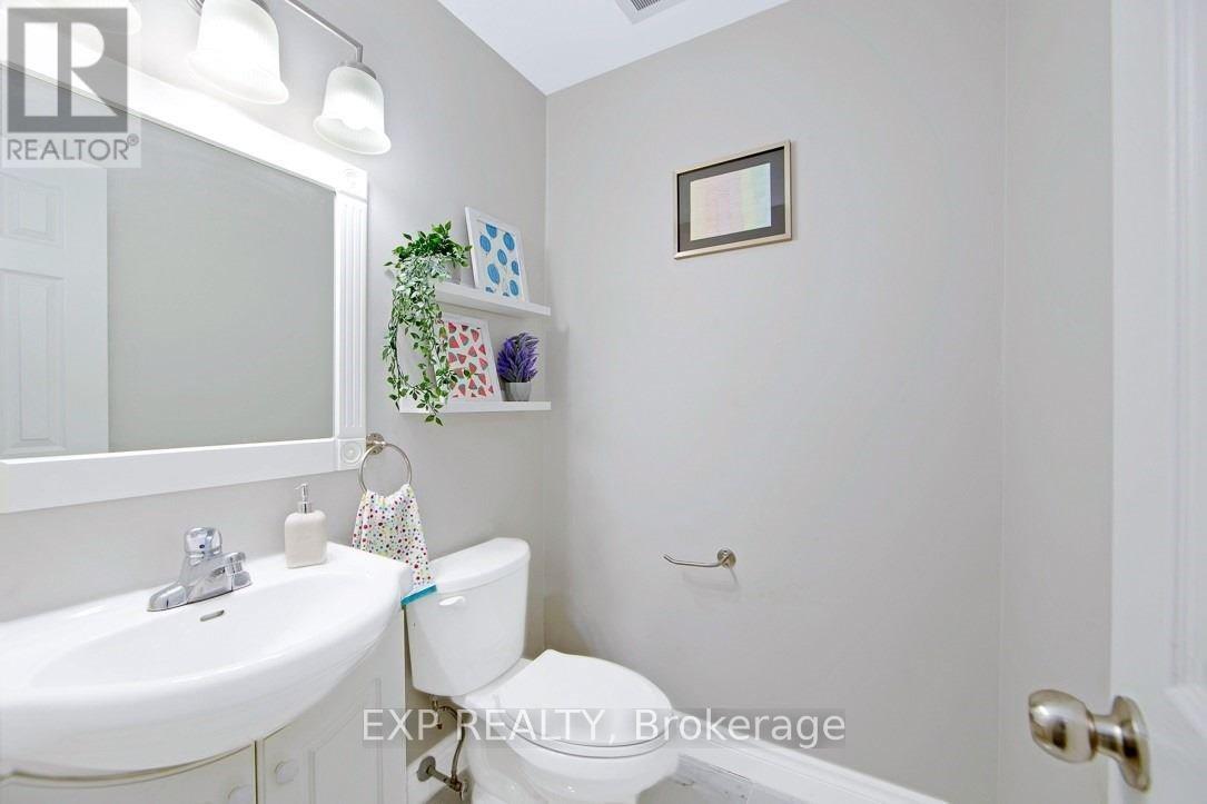 A white bathroom with a toilet, sink, and a mirror.