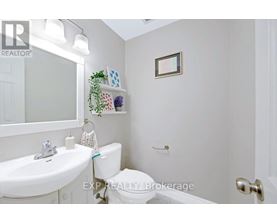 A white bathroom with a toilet, sink, and a mirror.