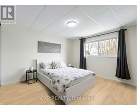 A bedroom with a bed, nightstand, and window.