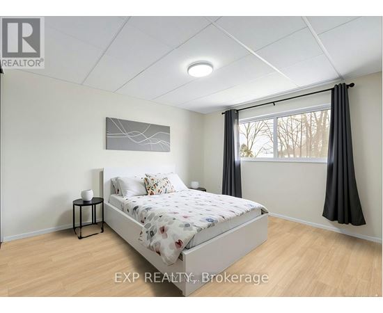 A bedroom with a bed, nightstand, and window.
