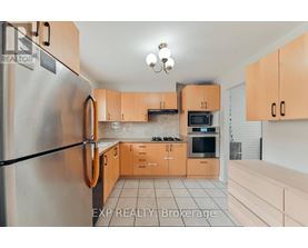 A kitchen with wooden cabinets and a refrigerator.