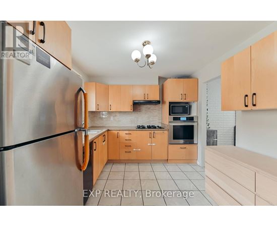 A kitchen with wooden cabinets and a refrigerator.