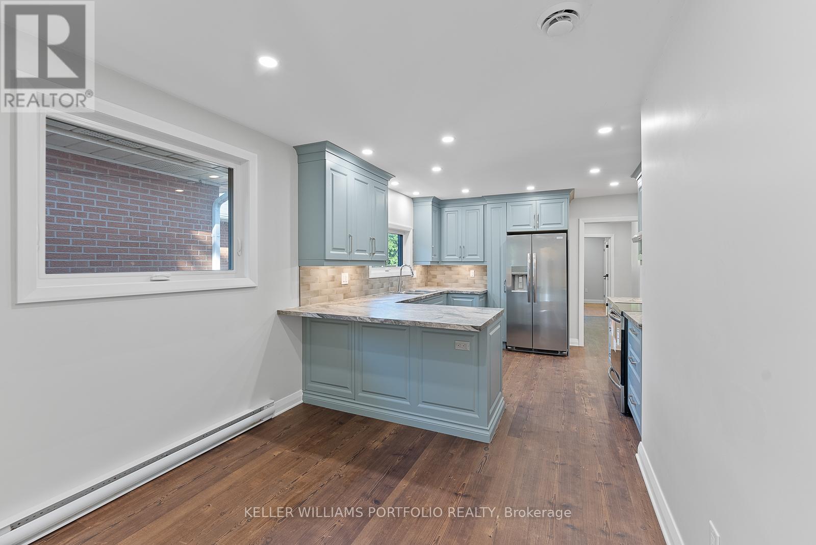 A kitchen with a blue cabinet and a fridge.
