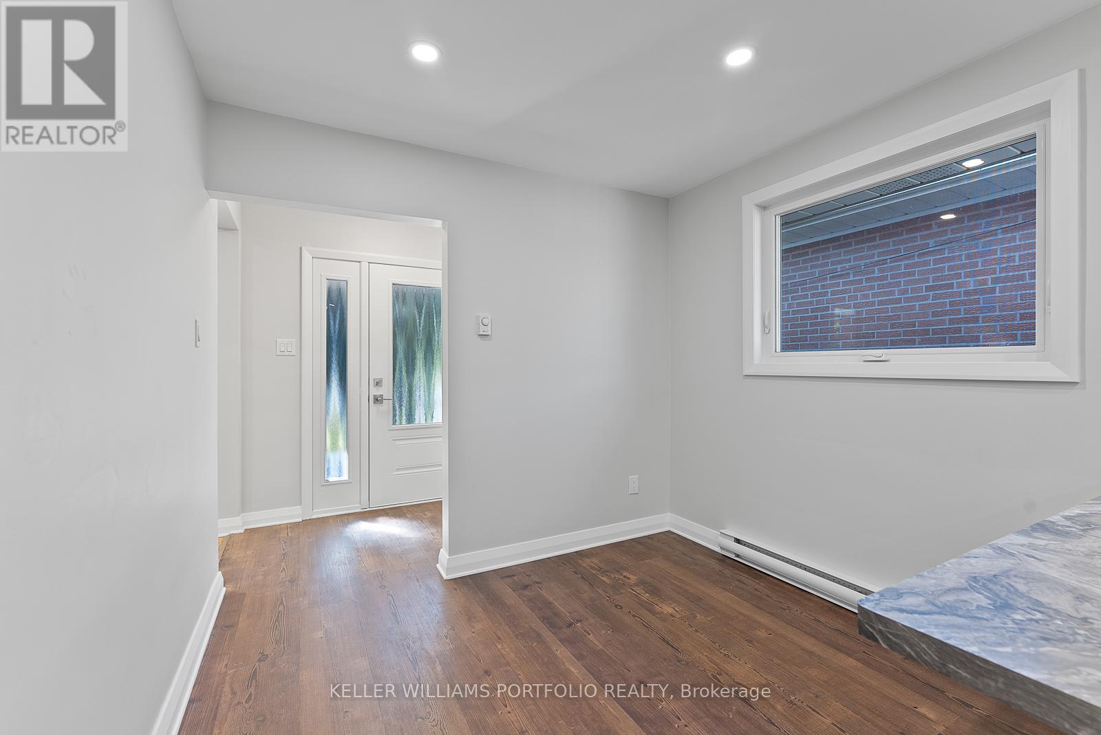 A bedroom with a bed, a window, and a door.