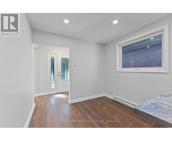 A bedroom with a bed, a window, and a door.