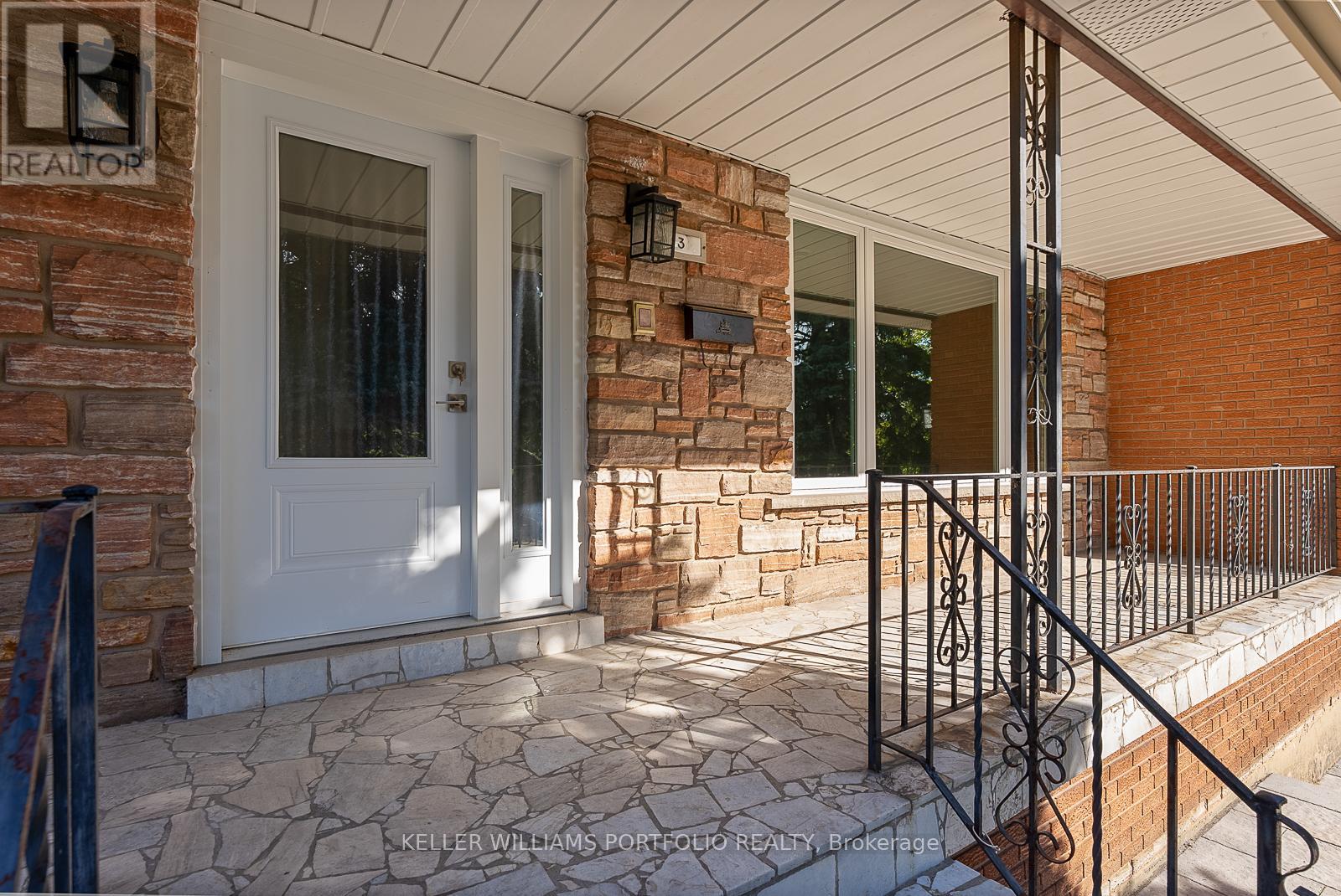 A house entrance with a white door and a brick wall.
