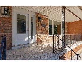 A house entrance with a white door and a brick wall.