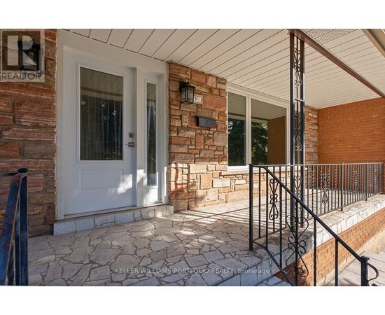 A house entrance with a white door and a brick wall.