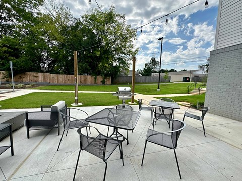 A patio with black metal furniture and a table.