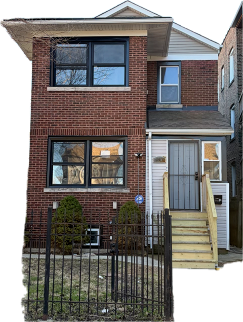 A red brick house with a grey door and a small window.