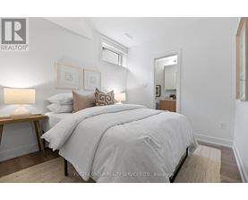 A bedroom with a large bed and a lamp on a side table.