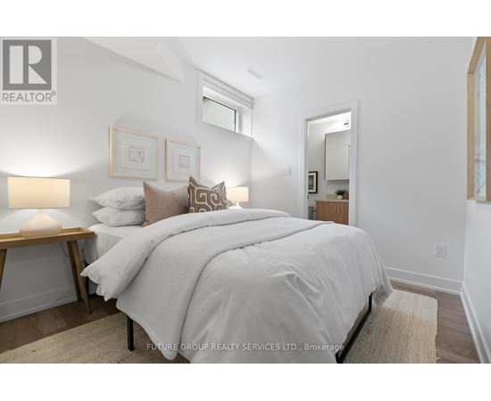 A bedroom with a large bed and a lamp on a side table.