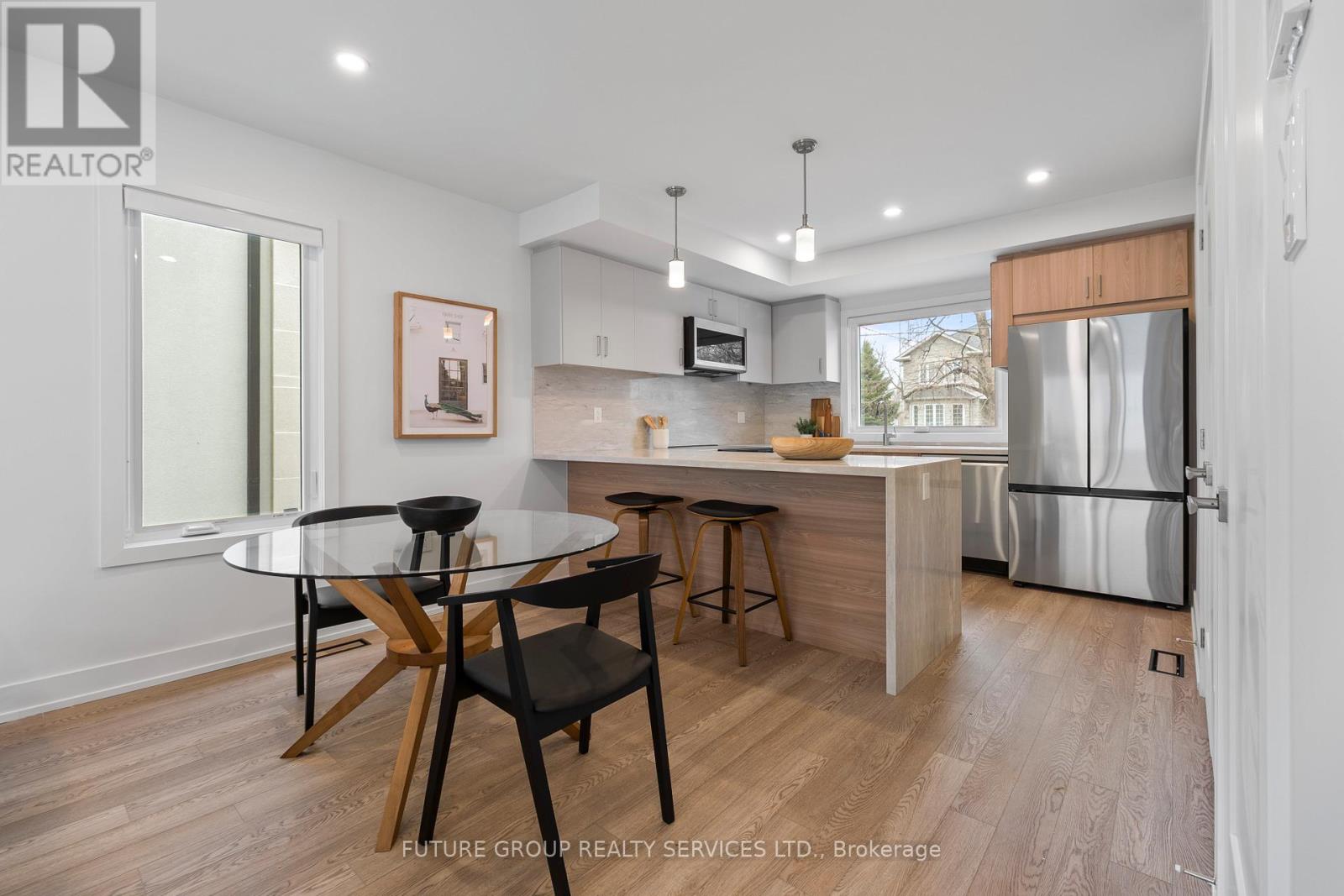 A modern kitchen with a glass table and bar stools.