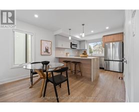 A modern kitchen with a glass table and bar stools.