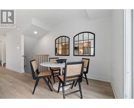 A dining room with a round table and chairs.