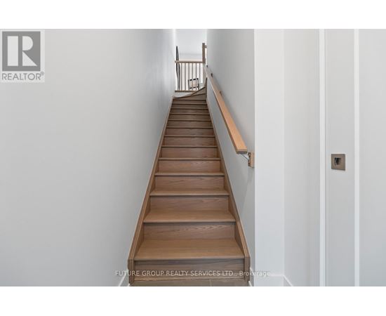 A long flight of wooden stairs with a handrail on the side.