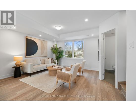 A well-lit, spacious living room with a large painting on the wall and a view of the outdoors through the window.