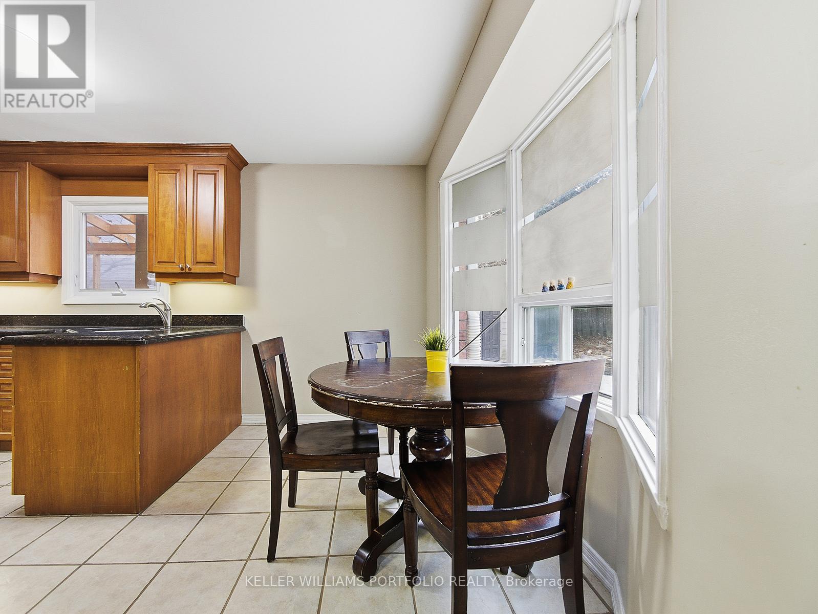 A kitchen with a table and chairs by a window.