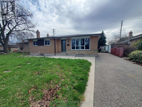 A house with a brown roof and a green lawn in front.