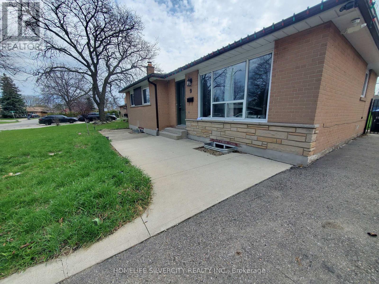 A brick house with a driveway in front.