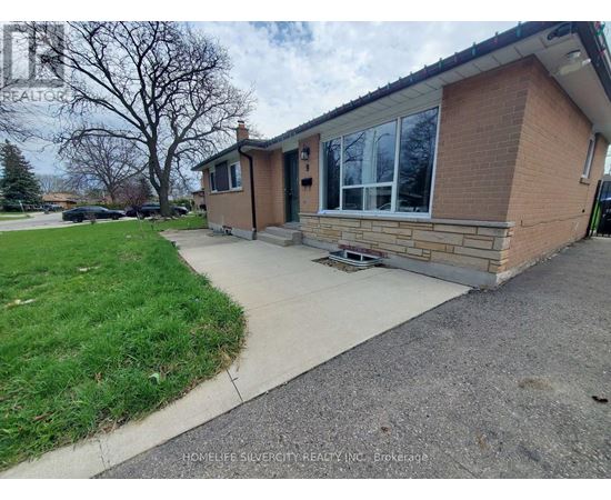 A brick house with a driveway in front.