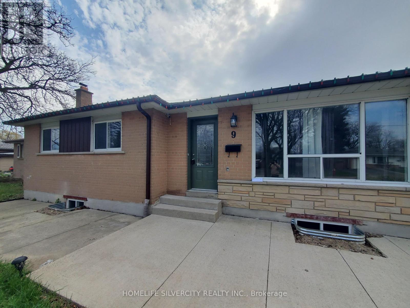 A house with a brick facade and a green door is for sale.
