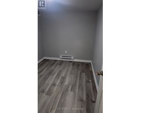 A room with wooden flooring and a white door.