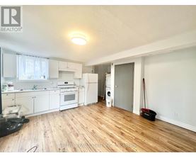 A kitchen with white appliances and wooden floors.