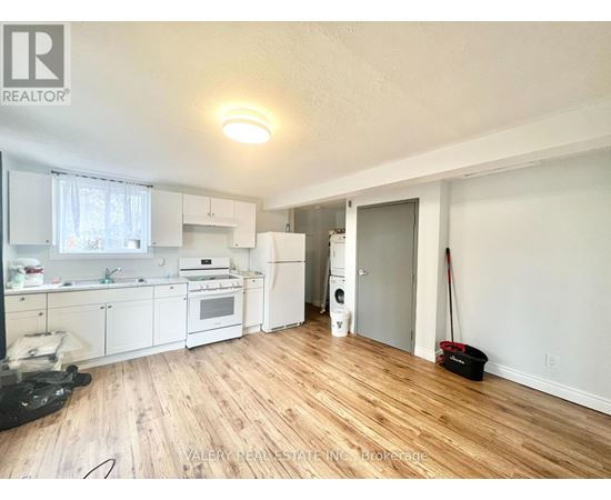 A kitchen with white appliances and wooden floors.