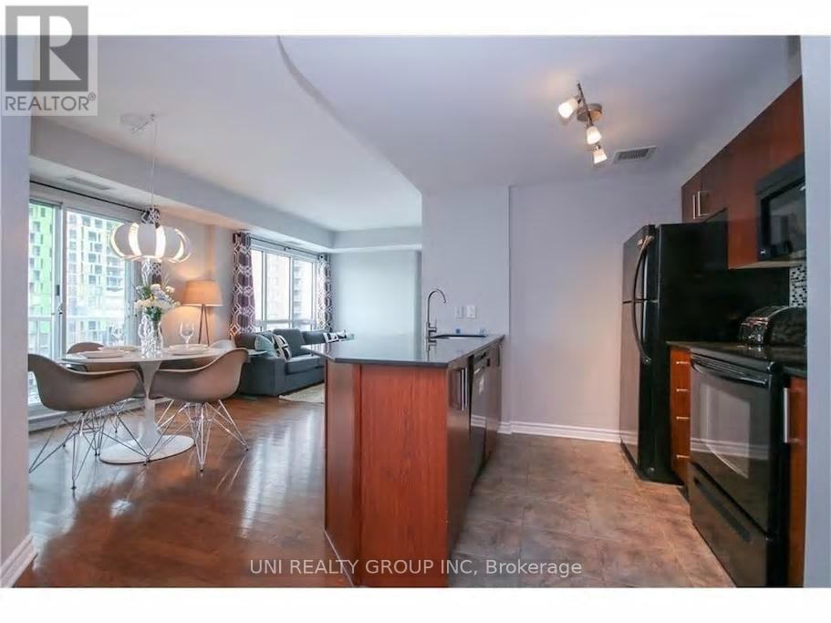 A kitchen with a black fridge and a black oven.