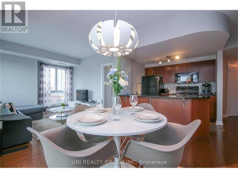 A modern dining room with a white table set for two.