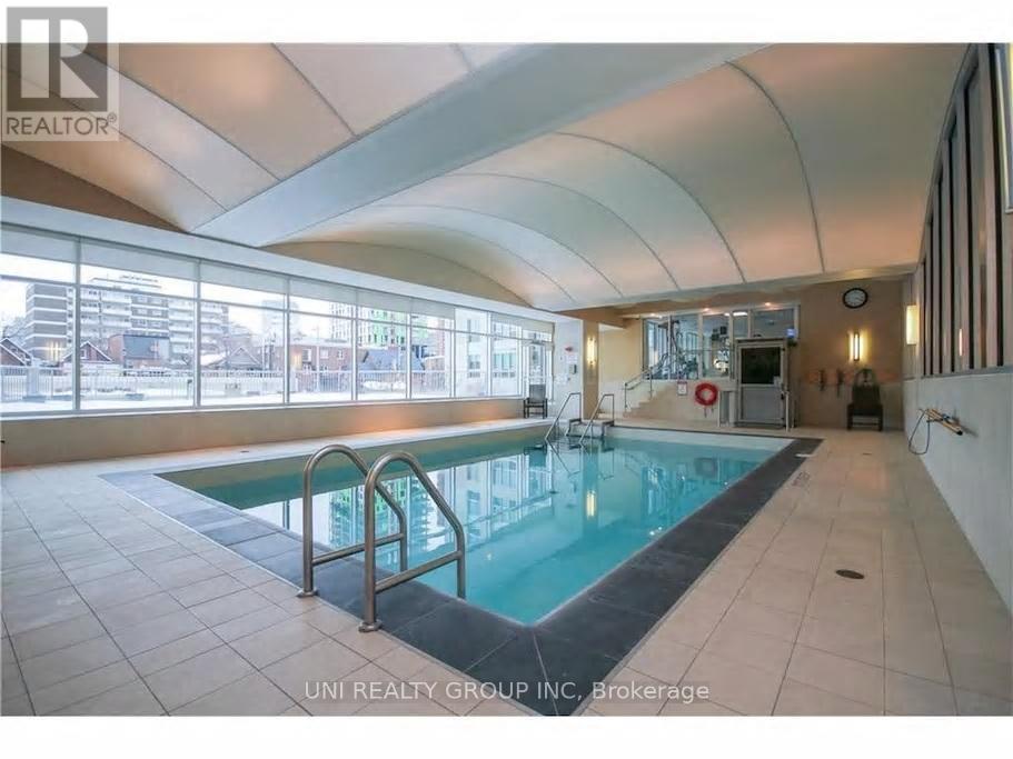 A large indoor swimming pool with a slide in a spacious room with a curved ceiling.