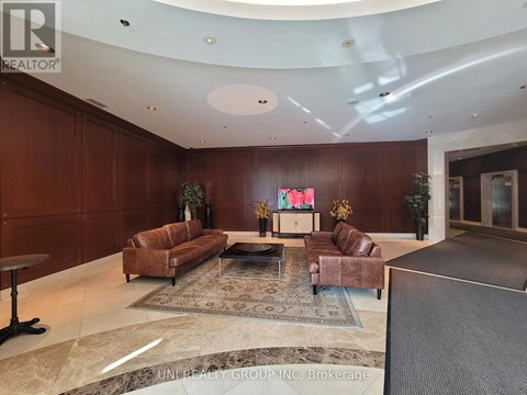 A living room with brown leather furniture and a large flat screen TV.