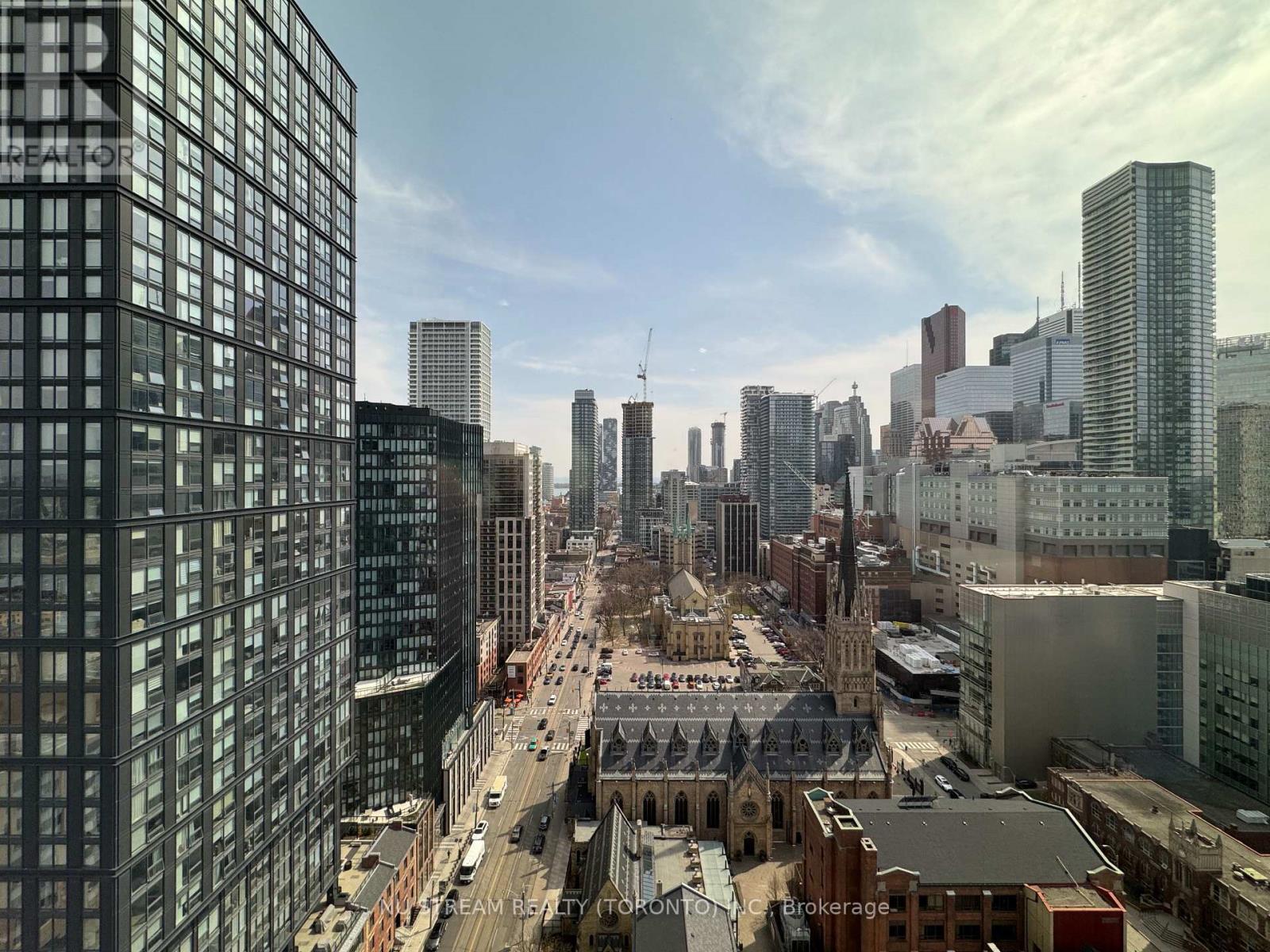 A cityscape with a mix of modern and older buildings, with a clear sky above.