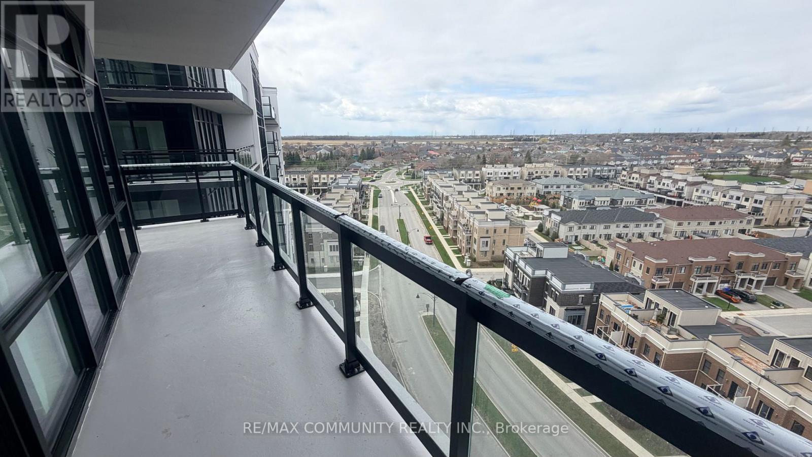 A balcony overlooks a cityscape with buildings and a highway.