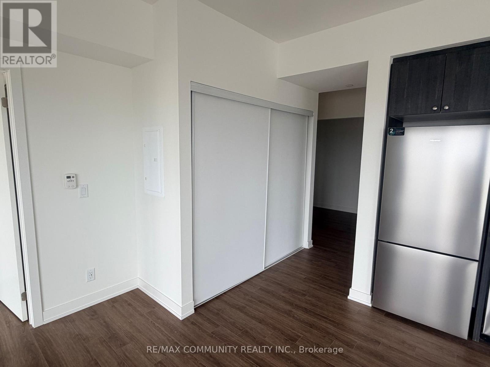 A kitchen area with a refrigerator and cabinets.