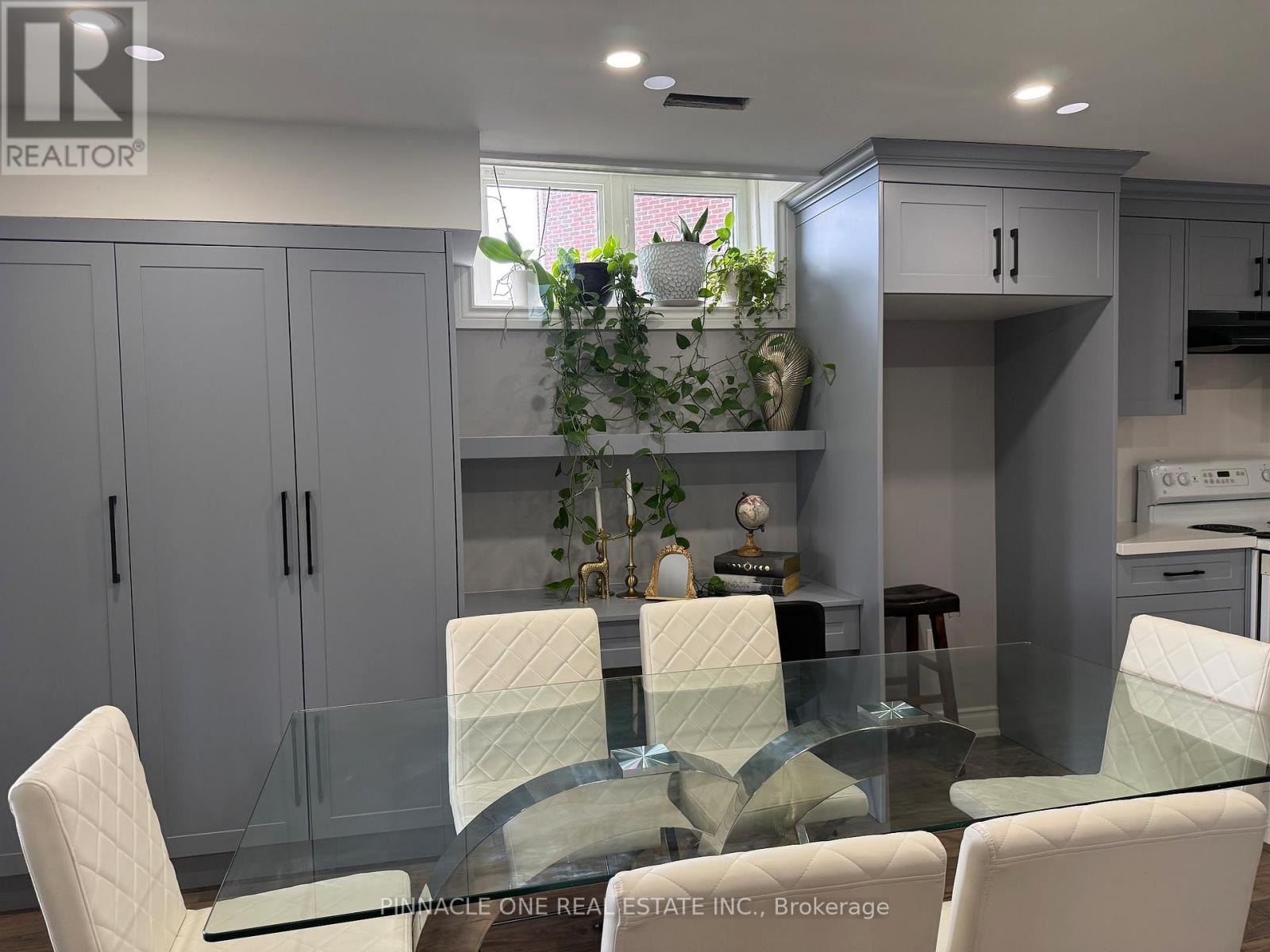 A modern kitchen with a glass table and white chairs.