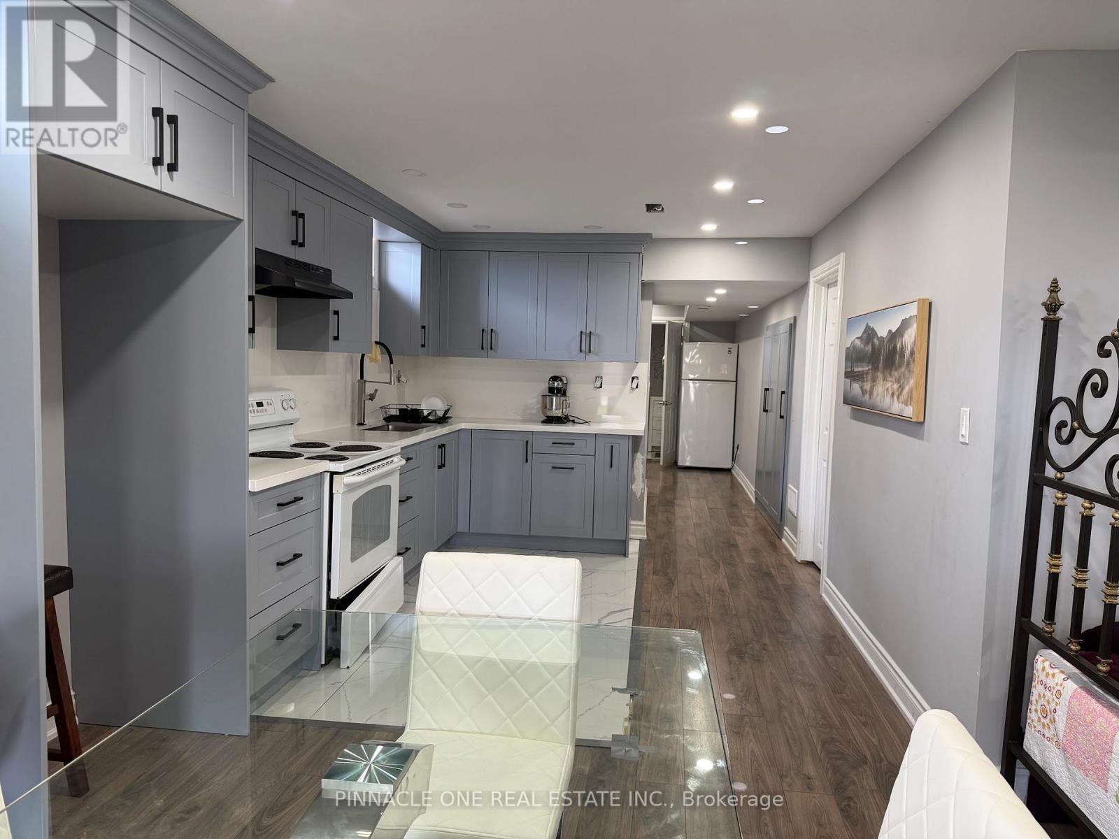 A modern kitchen with a glass table in the middle.