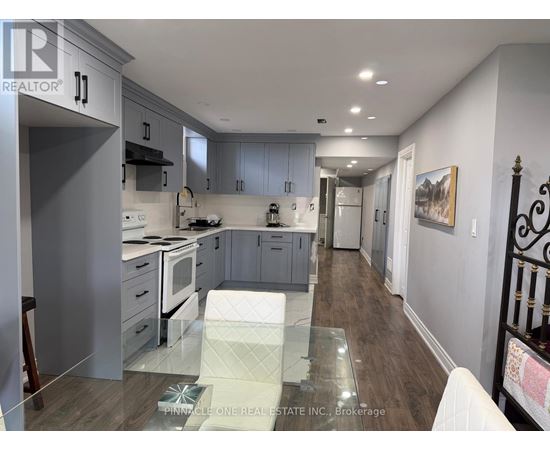 A modern kitchen with a glass table in the middle.