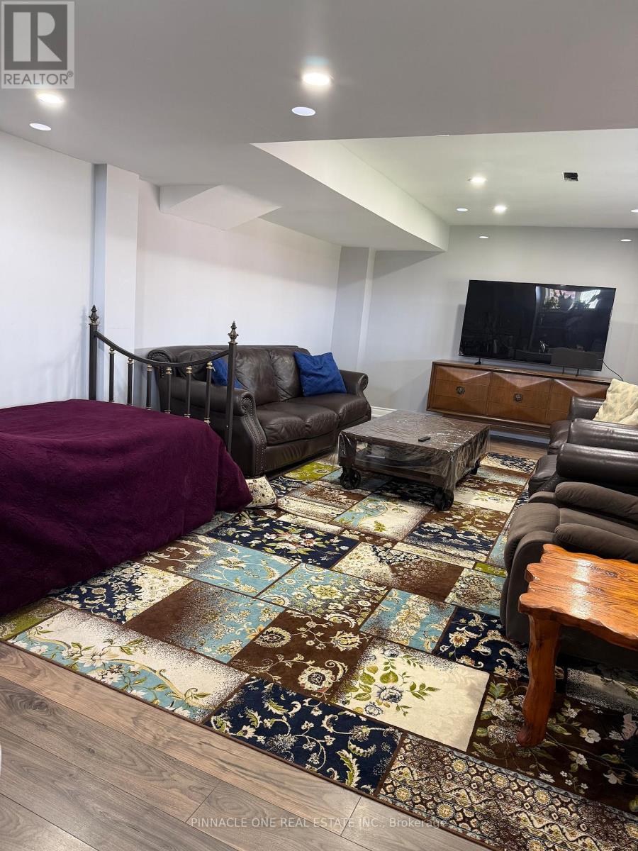 A living room with a brown sofa and a rug.