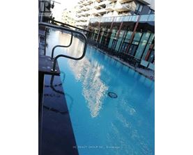 A pool with a metal railing on the side.
