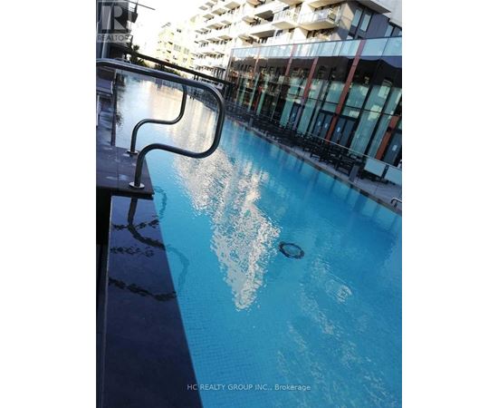 A pool with a metal railing on the side.