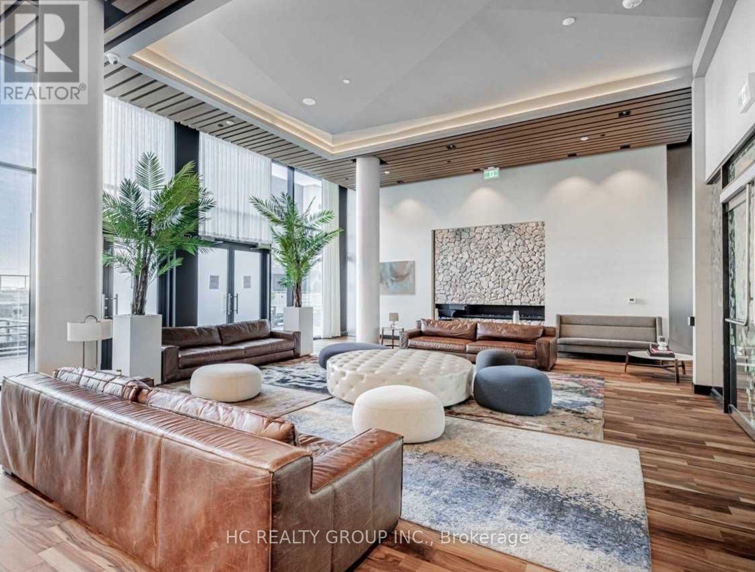 A modern living room with a brown leather sofa and a wooden floor.