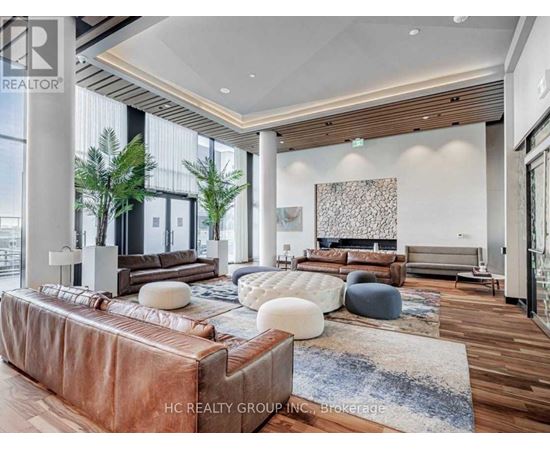 A modern living room with a brown leather sofa and a wooden floor.