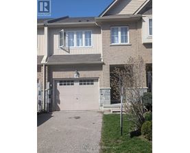 A house with a grey garage door and a brown roof.