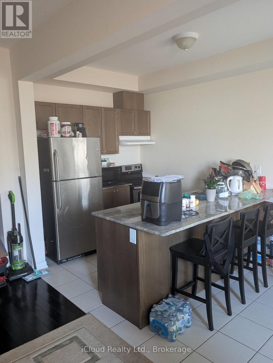 A kitchen with a refrigerator, oven, and sink.