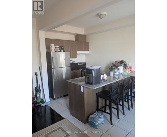 A kitchen with a refrigerator, oven, and sink.