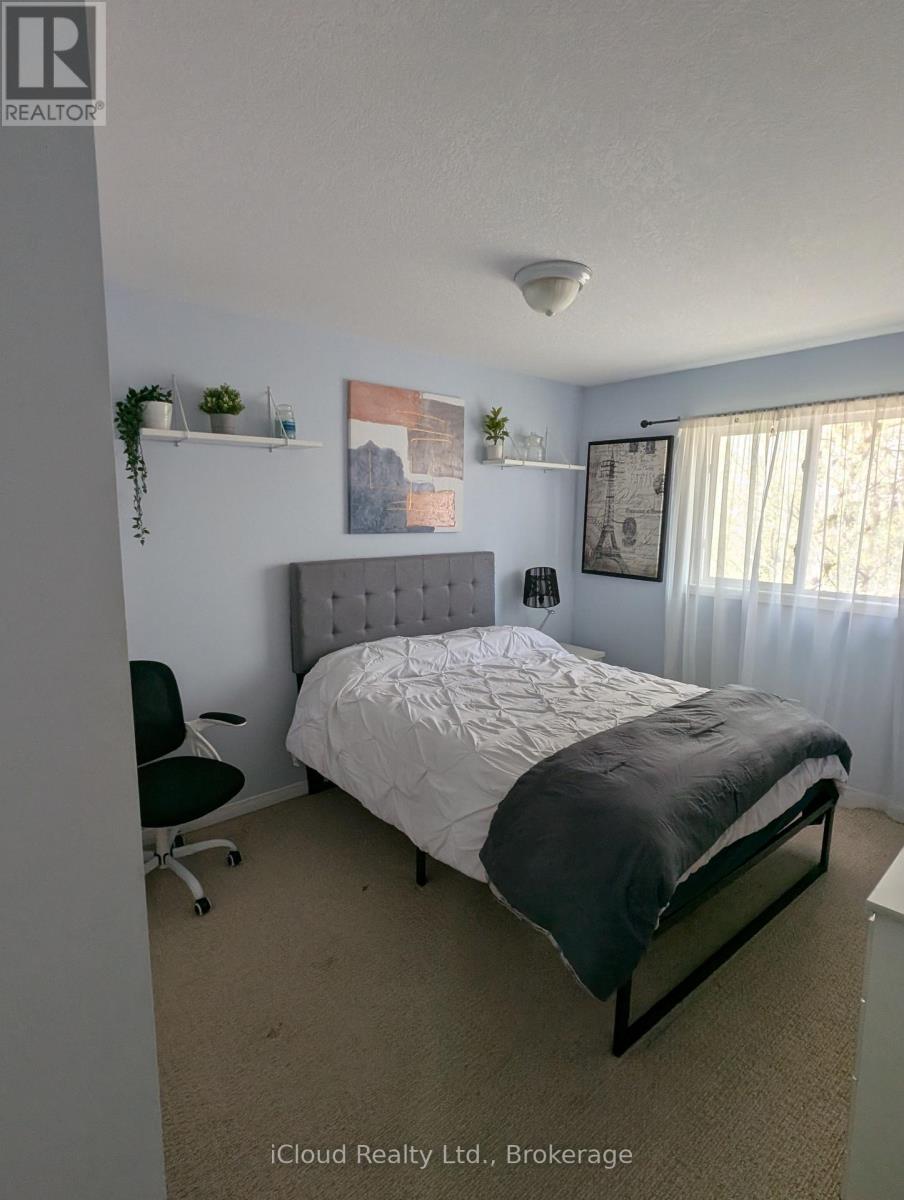 A bedroom with a bed, chair, and wall decorations.