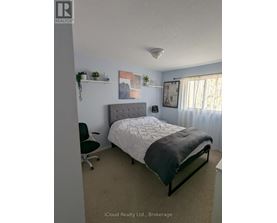 A bedroom with a bed, chair, and wall decorations.