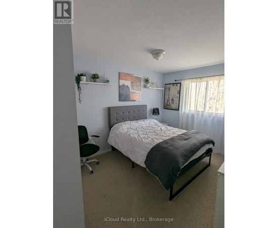 A bedroom with a bed, chair, and wall decorations.